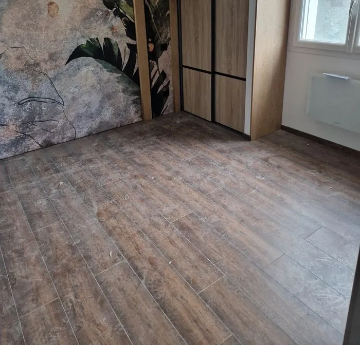 Sol stratifié poussiéreux et taché après travaux